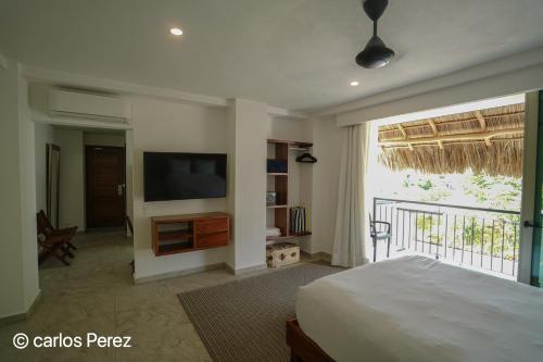 a bedroom with a bed and a flat screen tv at Hotel Puerto Sayulita in Sayulita