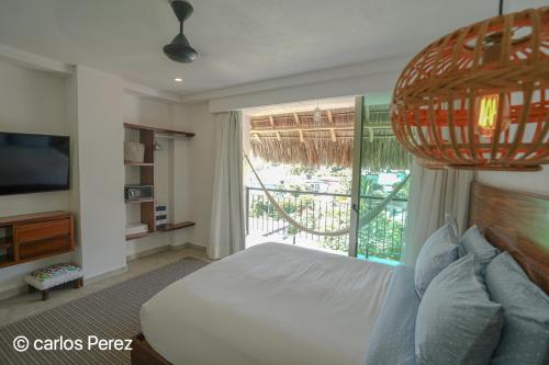 a bedroom with a bed and a large window at Hotel Puerto Sayulita in Sayulita