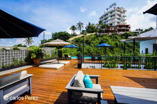 a deck with chairs and umbrellas on a building at Hotel Puerto Sayulita in Sayulita