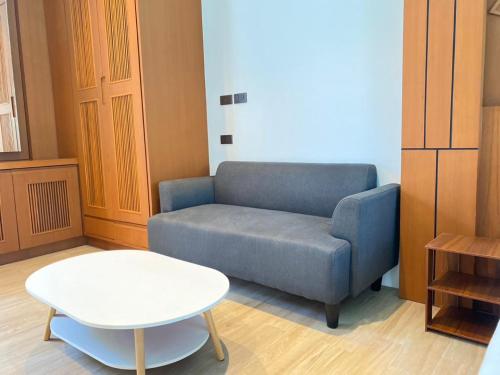 a living room with a blue couch and a table at Tajh Pool Villas in Chalong 