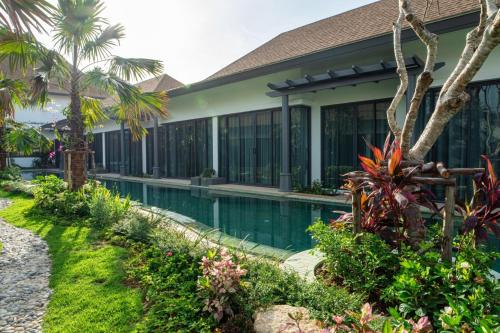 an exterior view of a resort with a swimming pool at Tajh Pool Villas in Chalong 