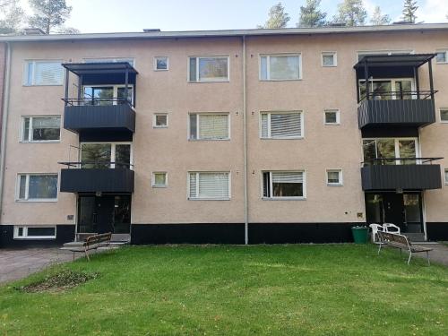 um edifício de apartamentos com duas varandas e um quintal em Apartments 15-20 block D em Kouvola