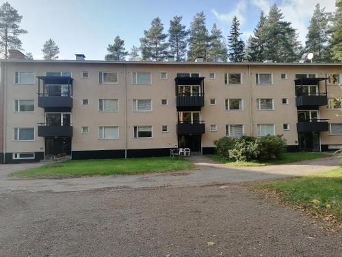 un edificio de apartamentos con un aparcamiento enfrente en Apartments 15-20 block D, en Kouvola