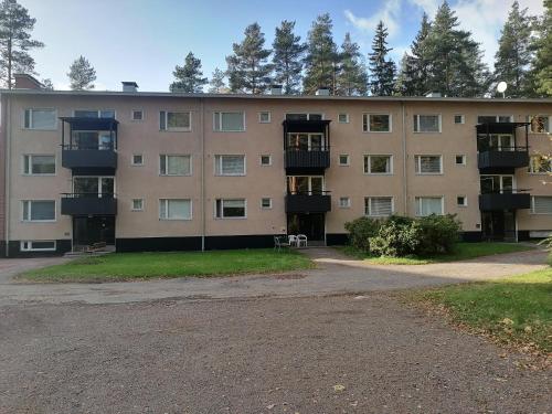 an apartment building with a parking lot in front of it at Apartments 15-20 block D in Kouvola