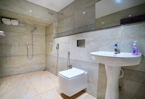 uma casa de banho com um lavatório, um WC e um chuveiro em 7 The Business Hotel em Alwaye
