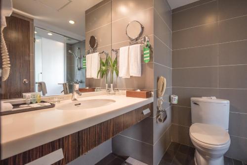 a bathroom with a sink and a toilet and a mirror at City Hotel Shanghai in Shanghai