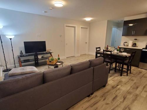 ein Wohnzimmer mit einem Sofa und einem Esszimmer in der Unterkunft Lux Modern 2BR Radiant Suite+Free Parking in Delta