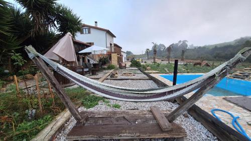 a hammock next to a house and a pool at Loft Estación Quintana in Gijón