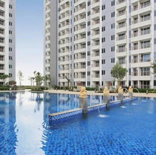 ein großer Pool vor einem großen Gebäude in der Unterkunft Arva Home in Surabaya