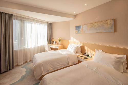上海市にあるシティホテル上海のベッド2台と窓が備わるホテルルームです。