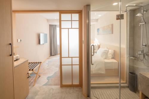 a bathroom with a shower and a bedroom with a bed at City Hotel Shanghai in Shanghai