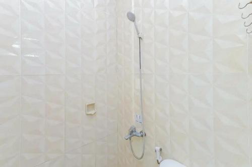a bathroom with a shower with a shower head at OYO 91292 Pondok Inap Shofwa 1 in Sidoarjo