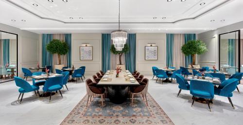 a dining room with tables and blue chairs at Address Jabal Omar Makkah in Makkah