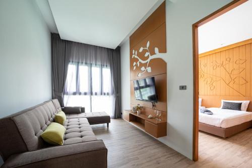 a living room with a couch and a bed and a mirror at Tajh Pool Villas in Chalong 