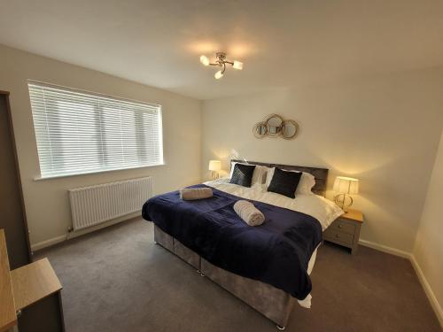 sypialnia z dużym łóżkiem i oknem w obiekcie Midland Close Bungalow - With separate office space by Catchpole Stays w mieście Colchester
