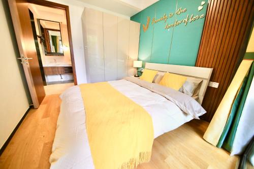 a bedroom with a large white bed with a blue wall at Colorful Yunnan Absolutely Beautiful Dian B&B in Kunming