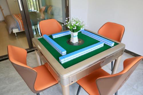 a table with orange chairs and a vase of flowers on it at Colorful Yunnan Absolutely Beautiful Dian B&B in Kunming