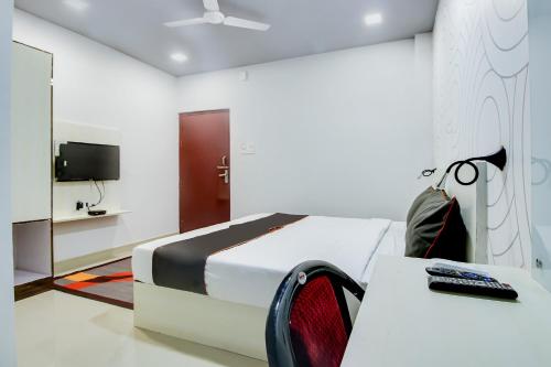 - une chambre avec un lit, une table et une télévision dans l'établissement Collection O Airport View Guest House Airport Road, à Soalkuchi