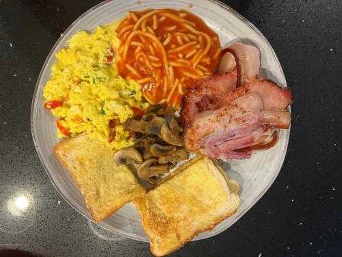 a plate of breakfast food with eggs mushrooms and toast at Country charm coastal living in Tura Beach