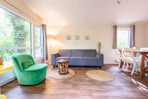 a living room with a couch and chairs and a table at Veluwe Chalet aan het bos - Kids - Pool - Dog in Hoenderloo
