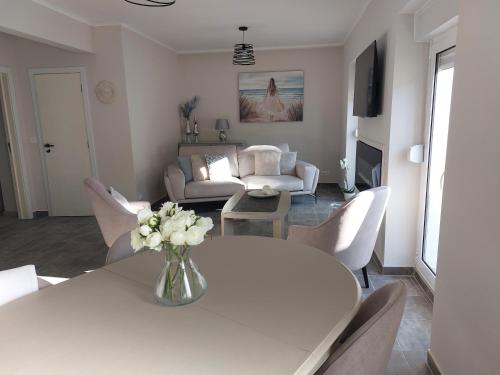 a living room with a white table and chairs at Casa Oasis in Fundão