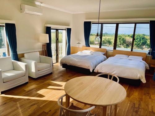 um quarto com 2 camas, uma mesa e uma cadeira em VILLA AZZURRA - Vacation STAY 63031v em Arazato