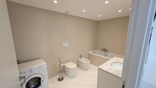 une salle de bain avec une machine à laver et un lavabo dans l'établissement The blue house, lovely apartment in the Côte d'Azur for 6 people, à Menton