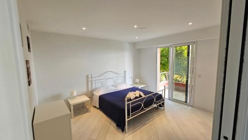 um quarto com uma cama e uma grande janela em The blue house, lovely apartment in the Côte d'Azur for 6 people em Menton