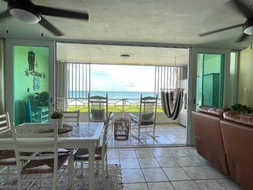 a dining room and living room with a view of the ocean at Oceanfront Retreat in Playa Fortuna, Puerto Rico in Luquillo