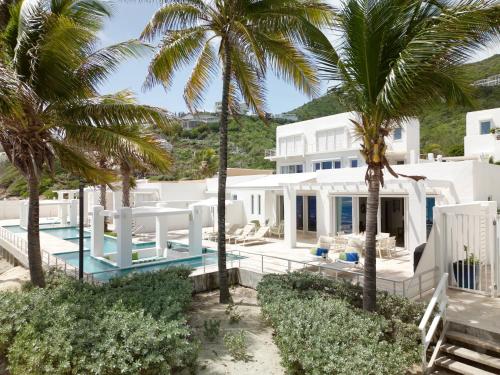 une villa avec une piscine et des palmiers dans l'établissement Oceanfront 5-Stars Starfish Villa, Dawn Beach, Private Pool, Secured, Concierge, à Oyster Pond