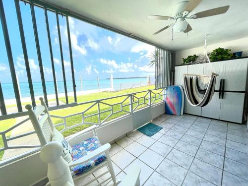 a room with a balcony with a view of the beach at Oceanfront Retreat in Playa Fortuna, Puerto Rico in Luquillo