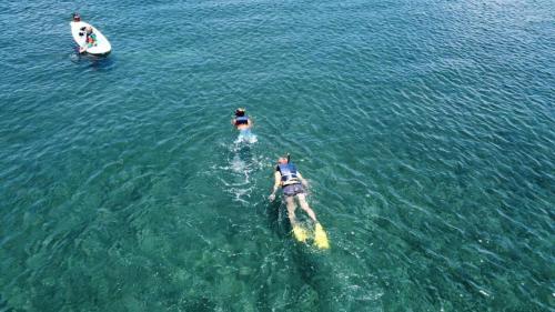 two people are in the water with a boat at Oceanfront Retreat in Playa Fortuna, Puerto Rico in Luquillo