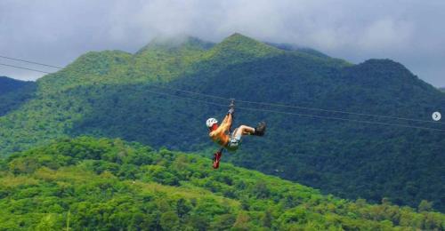a person is suspended in the air on a zip line at Oceanfront Retreat in Playa Fortuna, Puerto Rico in Luquillo