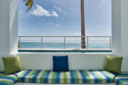 a balcony with a couch looking out at the ocean at Oceanfront 5-Stars Starfish Villa, Dawn Beach, Private Pool, Secured, Concierge in Oyster Pond