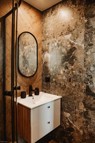 a bathroom with a sink and a mirror at Cichosza domki w Pieninach in Grywałd