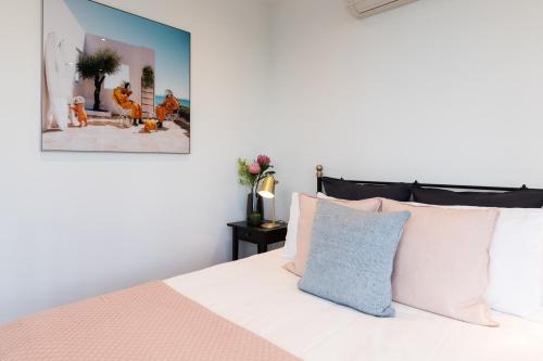 a bedroom with a white bed with pink and blue pillows at Fantastic Views at Luxury Prima Pearl Tower in Melbourne