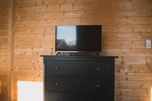 uma televisão em cima de uma cómoda num quarto em Naturnahes Familienchalet mit Garten - Wifi - Netflix - nur 15 Minuten vom Chiemsee und 35 Minuten von München entfernt em Vogtareuth