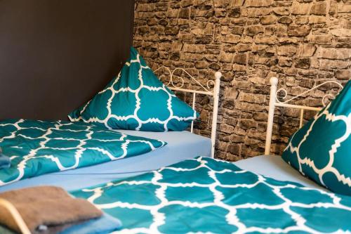 two beds with blue and white sheets and pillows at Kleines Häuschen für Monteure in Wörrstadt