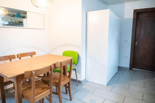 a dining room with a wooden table and green chairs at Kleines Häuschen für Monteure in Wörrstadt