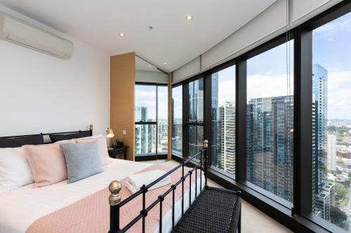 a bedroom with a bed and large windows at Fantastic Views at Luxury Prima Pearl Tower in Melbourne