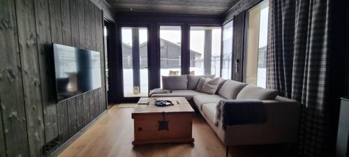 a living room with a couch and a coffee table at Kikut Alpin Lodge - Ski in, Ski out in Geilo
