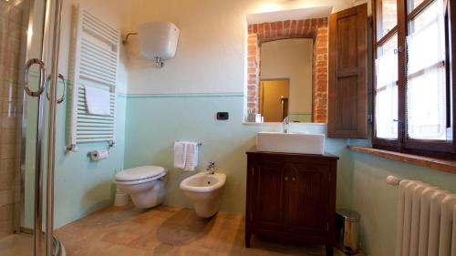 a bathroom with a toilet and a sink and a mirror at PODERE BELLARIA 18&2, Emma Villas in Rapolano Terme