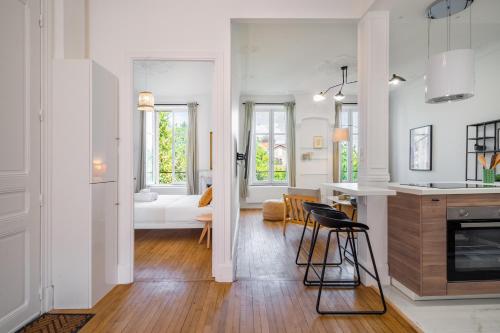 Il comprend une cuisine et un salon avec des murs blancs et du parquet. dans l'établissement Le Chic de Medreville * Nancy, à Nancy