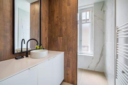 une salle de bain avec un lavabo et un miroir dans l'établissement Le Chic de Medreville * Nancy, à Nancy