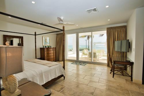a bedroom with a bed and a view of the ocean at Oceanfront 5-Stars Starfish Villa, Dawn Beach, Private Pool, Secured, Concierge in Oyster Pond