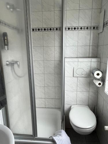 a small bathroom with a toilet and a shower at Brauhaus Hotel Ruetershoff in Castrop-Rauxel