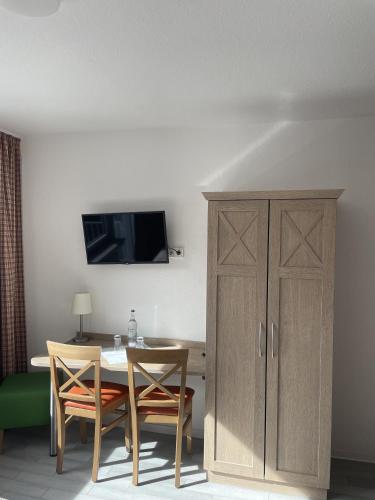 a dining room with a table and a cabinet at Brauhaus Hotel Ruetershoff in Castrop-Rauxel