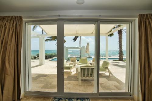 a living room with sliding glass doors looking out at the ocean at Oceanfront 5-Stars Starfish Villa, Dawn Beach, Private Pool, Secured, Concierge in Oyster Pond