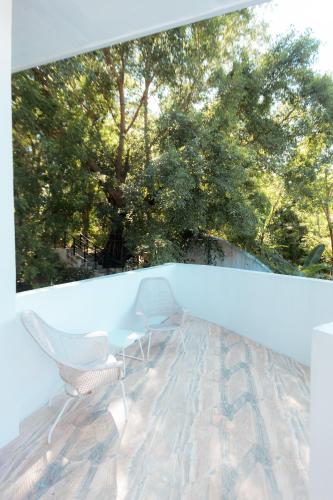a balcony with two chairs and a view of trees at Bellagio Hills Hotel and Restaurant in Paoay