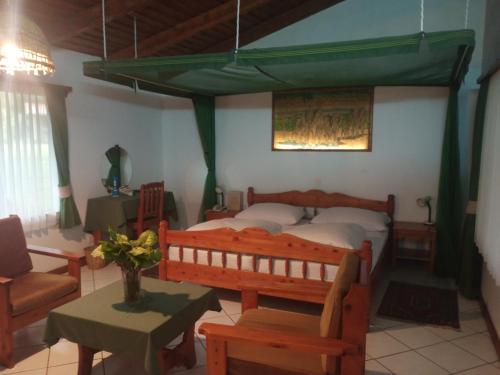 a bedroom with a bed and a couch and a table at Dik Dik Hotel in Arusha